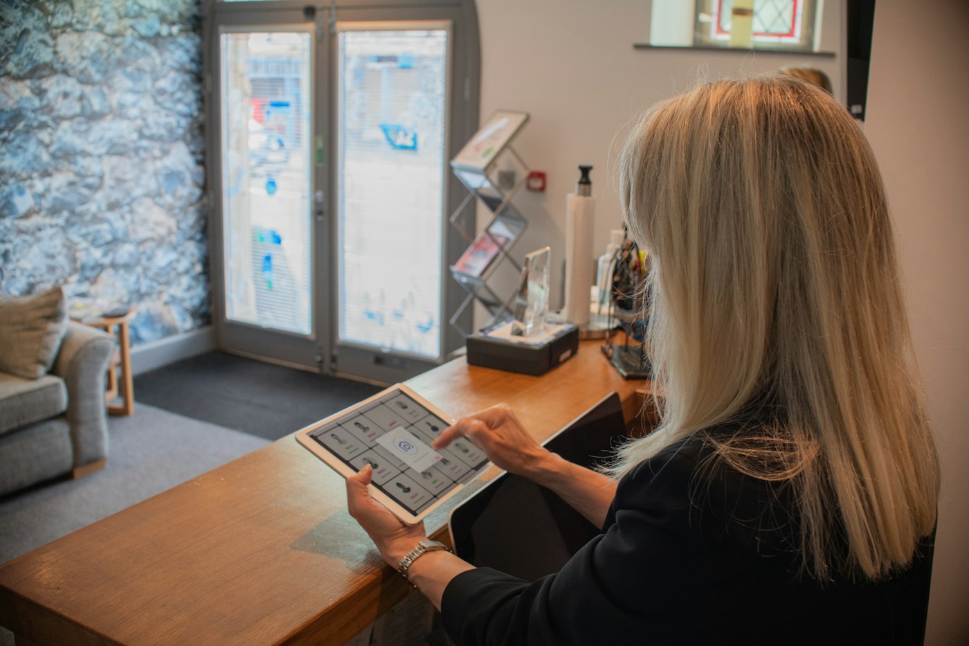 A receptionist with a tablet at the front desk